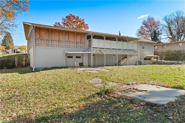 rear view of house featuring a sunroom and a lawn