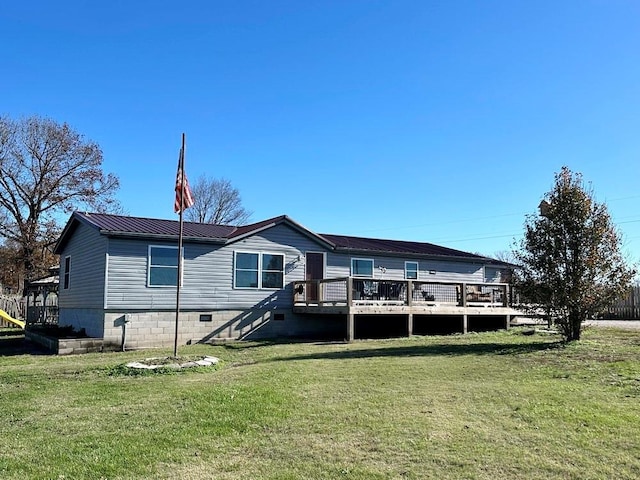 back of property featuring a wooden deck and a lawn