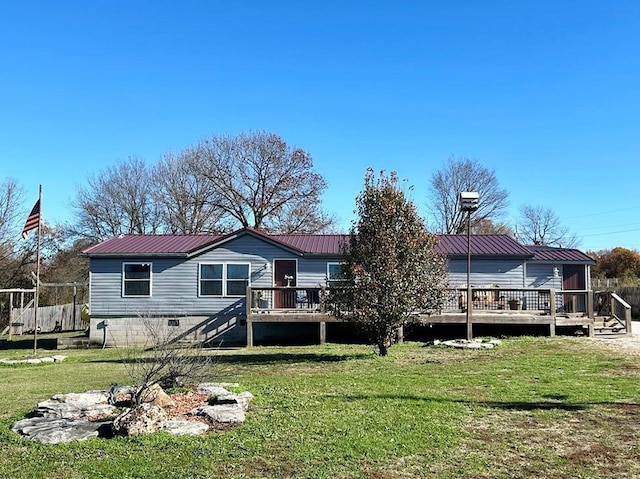 back of property featuring a wooden deck and a lawn