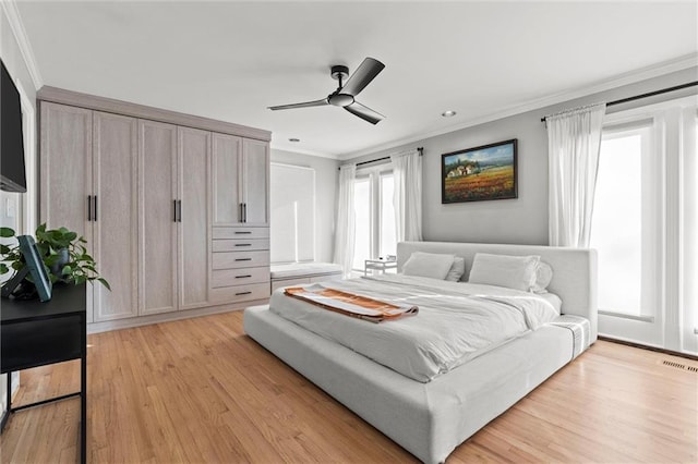 bedroom featuring crown molding, light wood-type flooring, and ceiling fan