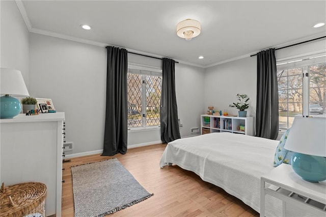 bedroom with multiple windows, ornamental molding, and light wood-type flooring