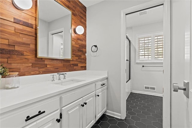 bathroom with tile patterned flooring, vanity, and wooden walls