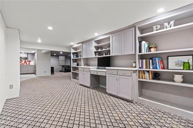 interior space featuring built in desk and gray cabinetry