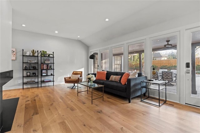 living room featuring lofted ceiling and light hardwood / wood-style floors