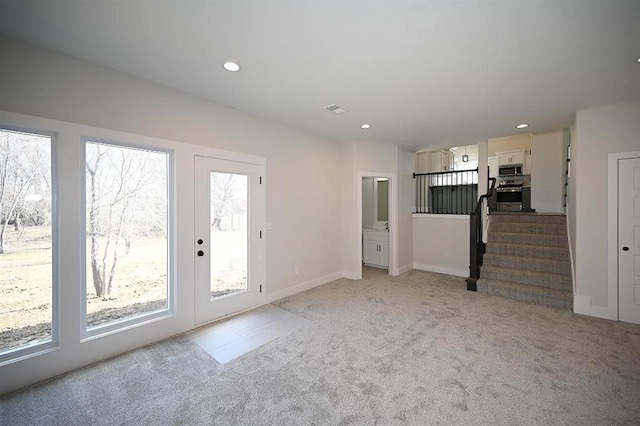 unfurnished living room featuring light carpet