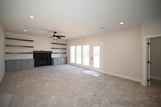 unfurnished living room featuring light colored carpet and ceiling fan