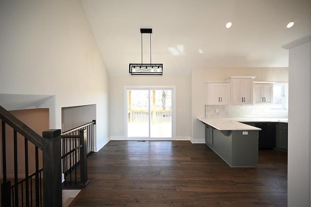 kitchen with pendant lighting, light stone countertops, dark hardwood / wood-style flooring, and white cabinetry