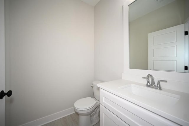 bathroom with vanity, wood-type flooring, and toilet