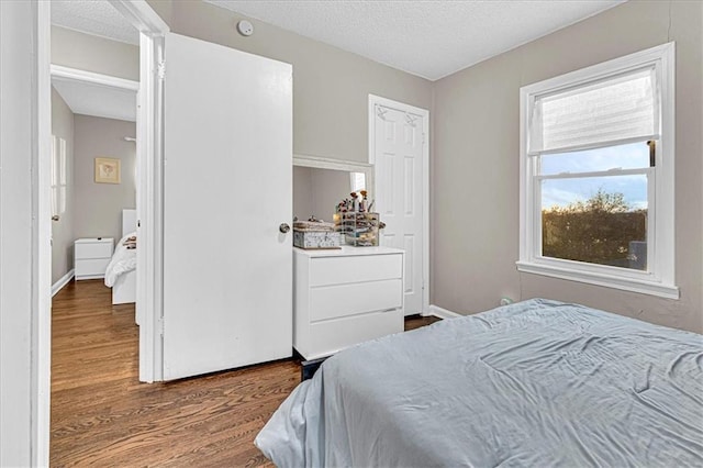 bedroom with a textured ceiling and hardwood / wood-style flooring