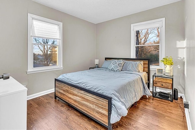 bedroom featuring wood-type flooring and multiple windows