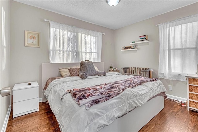 bedroom featuring a textured ceiling and dark wood-type flooring