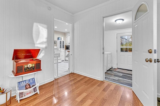 entrance foyer featuring hardwood / wood-style floors, crown molding, and washing machine and clothes dryer