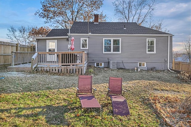 rear view of property featuring a yard, central AC unit, and a deck