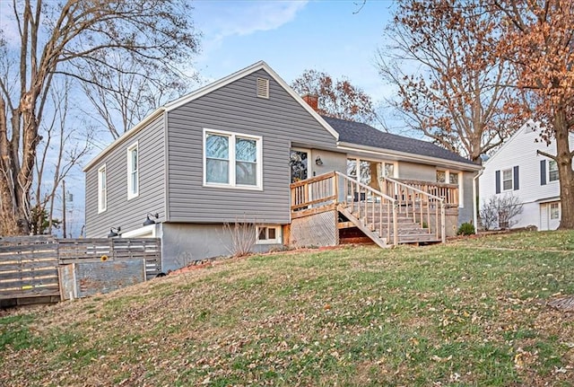 rear view of house featuring a deck and a lawn