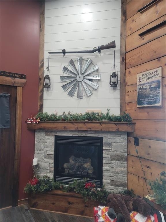 details featuring a fireplace, wood-type flooring, and wood walls