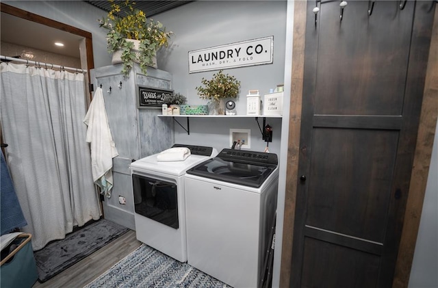 laundry room featuring washer and clothes dryer and light wood-type flooring