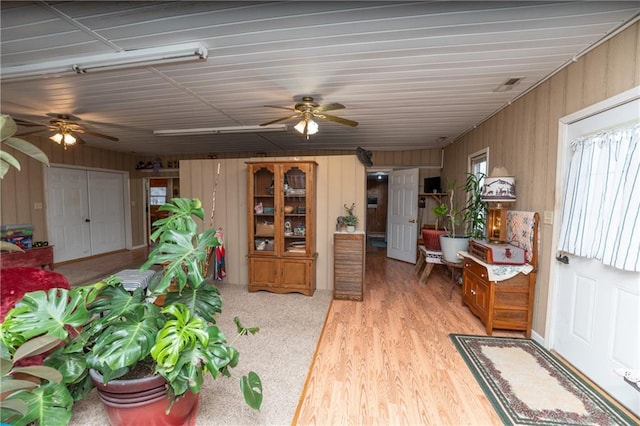 interior space with wooden walls and light hardwood / wood-style flooring