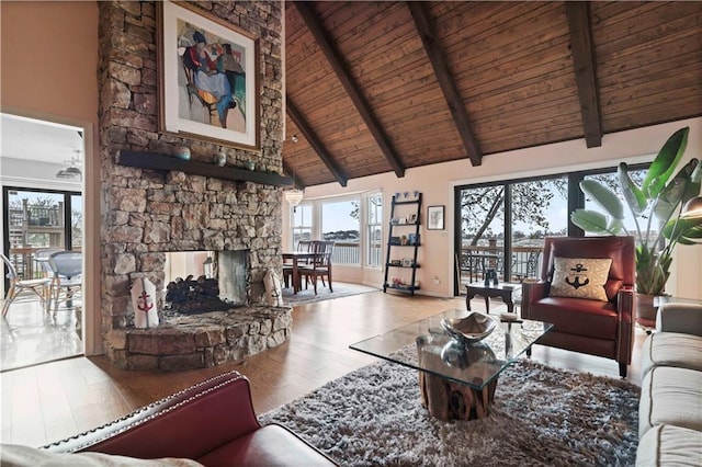 living room featuring a fireplace, light wood-type flooring, high vaulted ceiling, and beamed ceiling