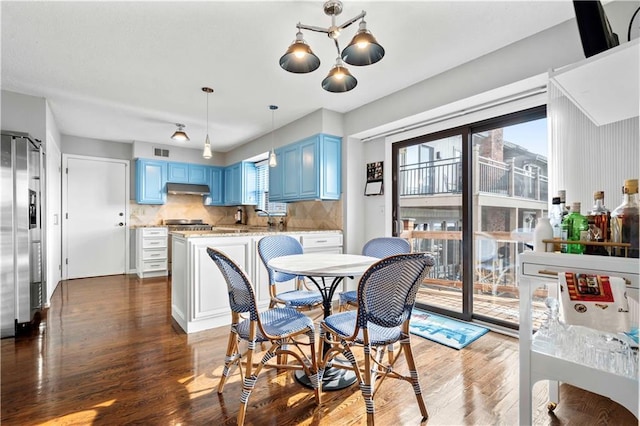 dining room featuring a chandelier, dark hardwood / wood-style flooring, a wealth of natural light, and sink