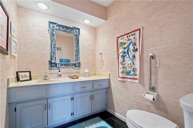 bathroom featuring tile patterned flooring, vanity, and toilet