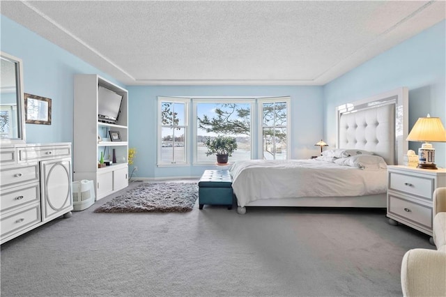 bedroom with a textured ceiling and dark carpet