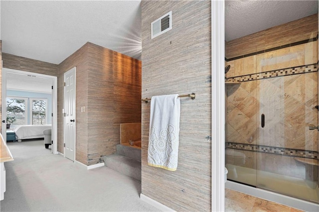 bathroom featuring wood walls, toilet, a shower with door, and a textured ceiling