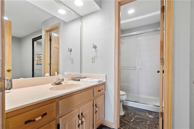 bathroom featuring toilet, vanity, and walk in shower