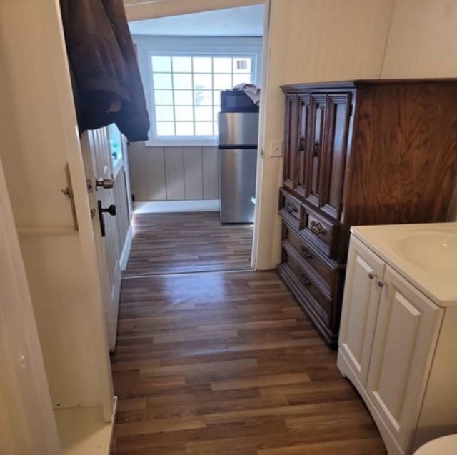 corridor with dark hardwood / wood-style flooring and sink