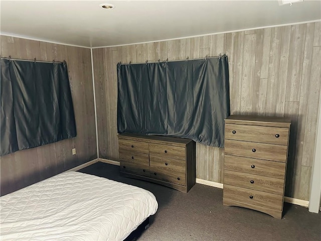 carpeted bedroom featuring wood walls