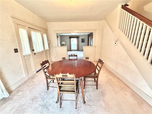 carpeted dining space featuring french doors