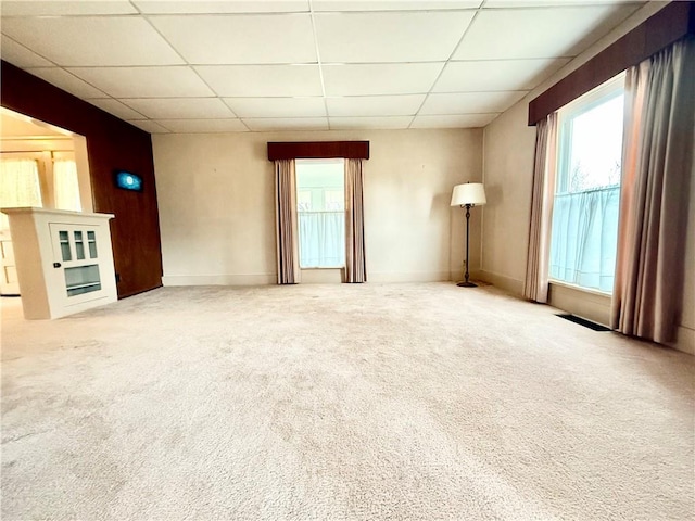 unfurnished living room with carpet and a drop ceiling