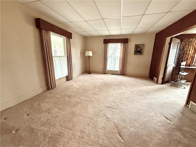 unfurnished room with a paneled ceiling and carpet floors