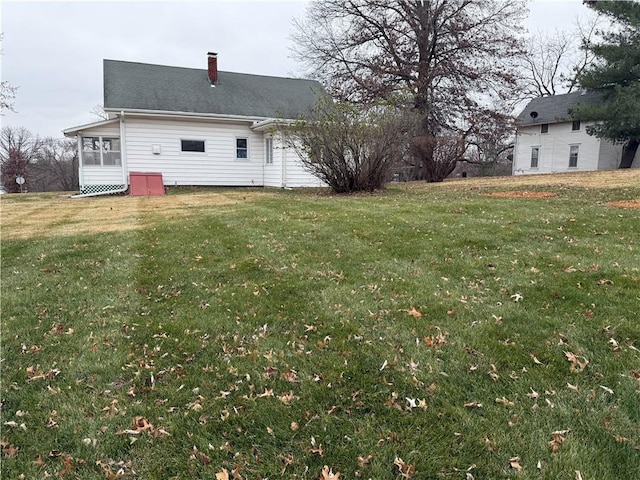 rear view of property with a yard