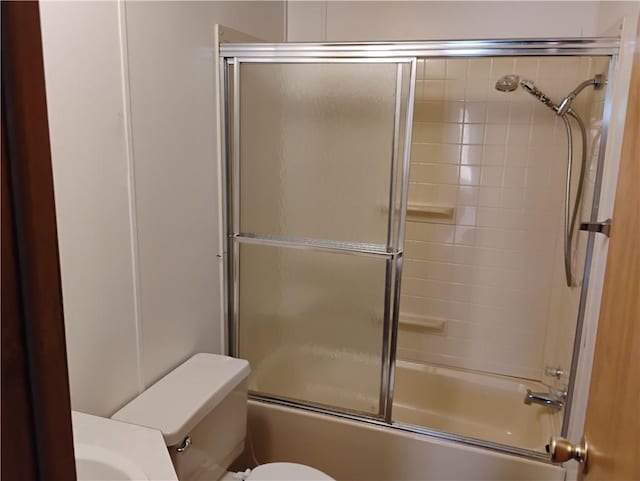 bathroom with shower / bath combination with glass door and toilet