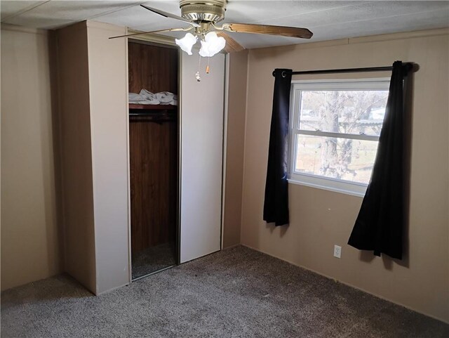 unfurnished bedroom with carpet flooring, ceiling fan, and a closet