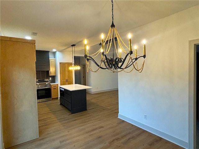 kitchen featuring stainless steel range, tasteful backsplash, dark hardwood / wood-style floors, decorative light fixtures, and a kitchen island