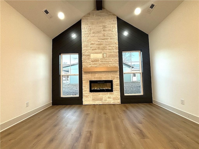 unfurnished living room with a fireplace, hardwood / wood-style floors, high vaulted ceiling, and beam ceiling