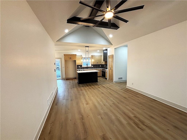 unfurnished living room with lofted ceiling with beams, dark hardwood / wood-style floors, and ceiling fan