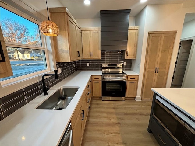 kitchen featuring sink, light brown cabinets, tasteful backsplash, decorative light fixtures, and stainless steel range with electric stovetop