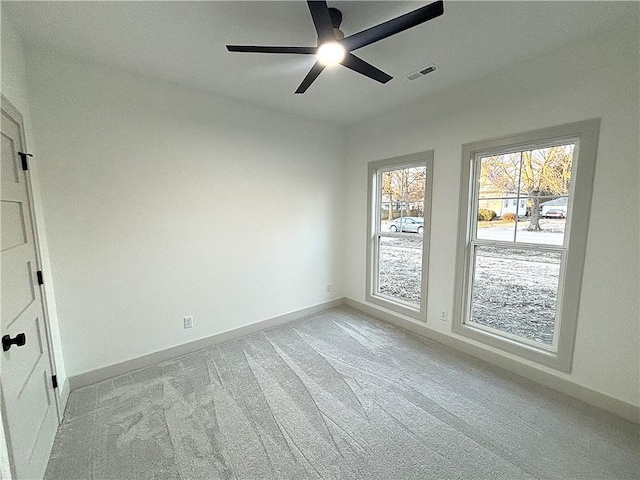 carpeted spare room featuring ceiling fan