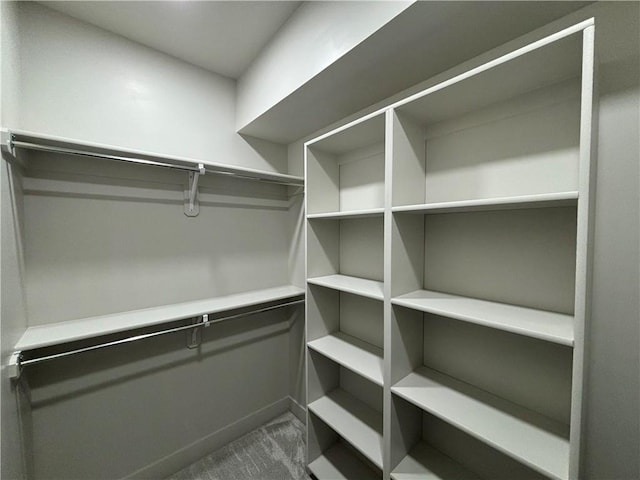 spacious closet featuring dark carpet