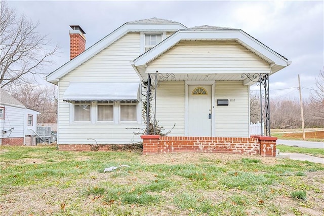 bungalow with covered porch and a front lawn