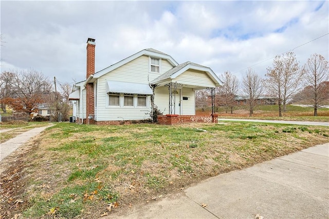 view of front of home with cooling unit and a front lawn