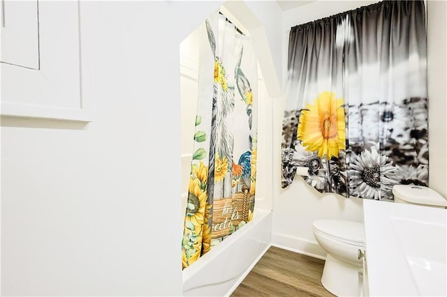 bathroom featuring hardwood / wood-style floors, toilet, and shower / bathtub combination with curtain