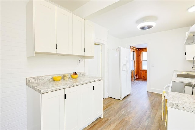 kitchen featuring light hardwood / wood-style flooring, white cabinets, stove, and white refrigerator with ice dispenser