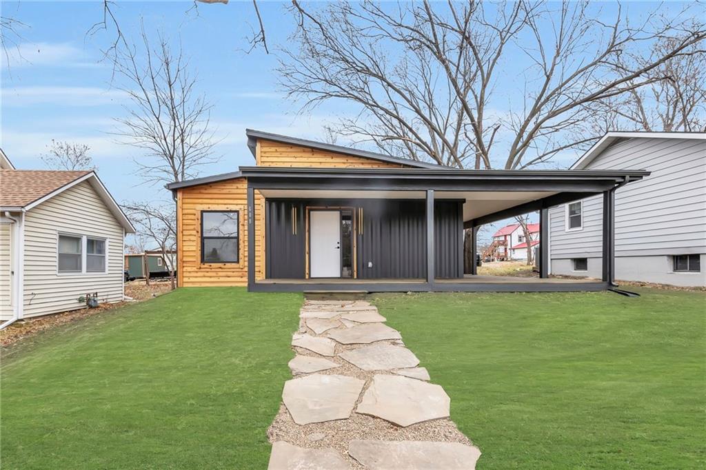 view of front of property featuring a front yard and a carport