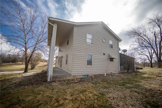 view of side of property with a lawn and a patio