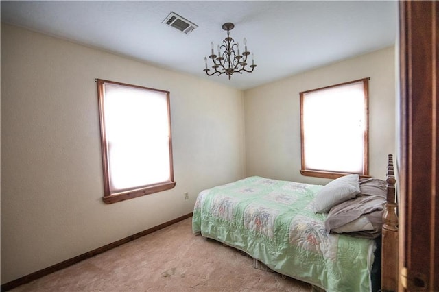 carpeted bedroom featuring multiple windows and a chandelier