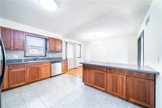 kitchen with dishwasher, sink, a notable chandelier, backsplash, and decorative light fixtures