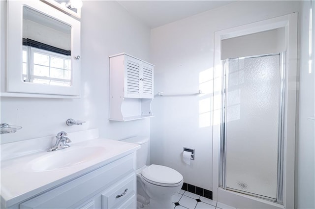 bathroom featuring tile patterned flooring, vanity, a shower with shower door, and toilet